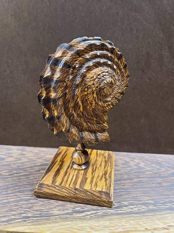 Beautiful wooden sculpture of spiral shell on a stand