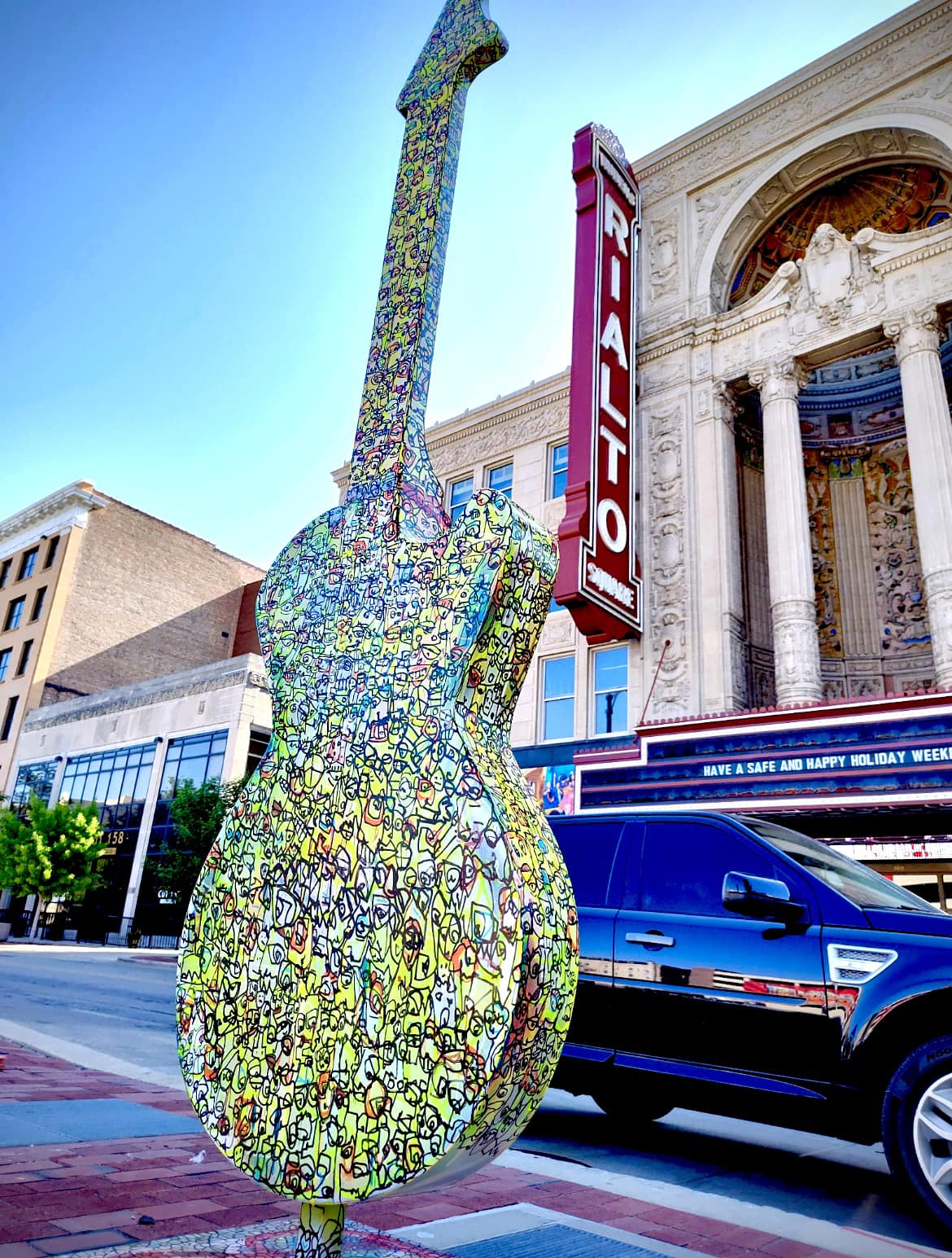 guitar statue with multipe lines and colors mostly yellow