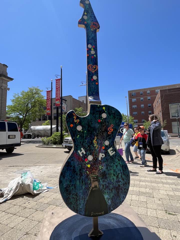 Guitar statue dark color with "hope" painted on it