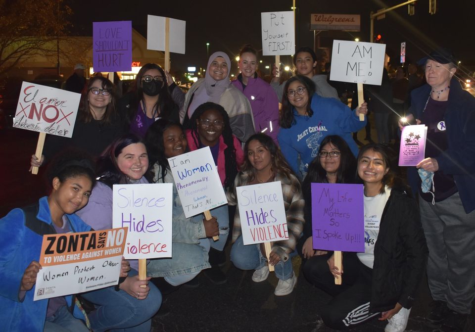 Group of women of all ages folding signs against domestic violence