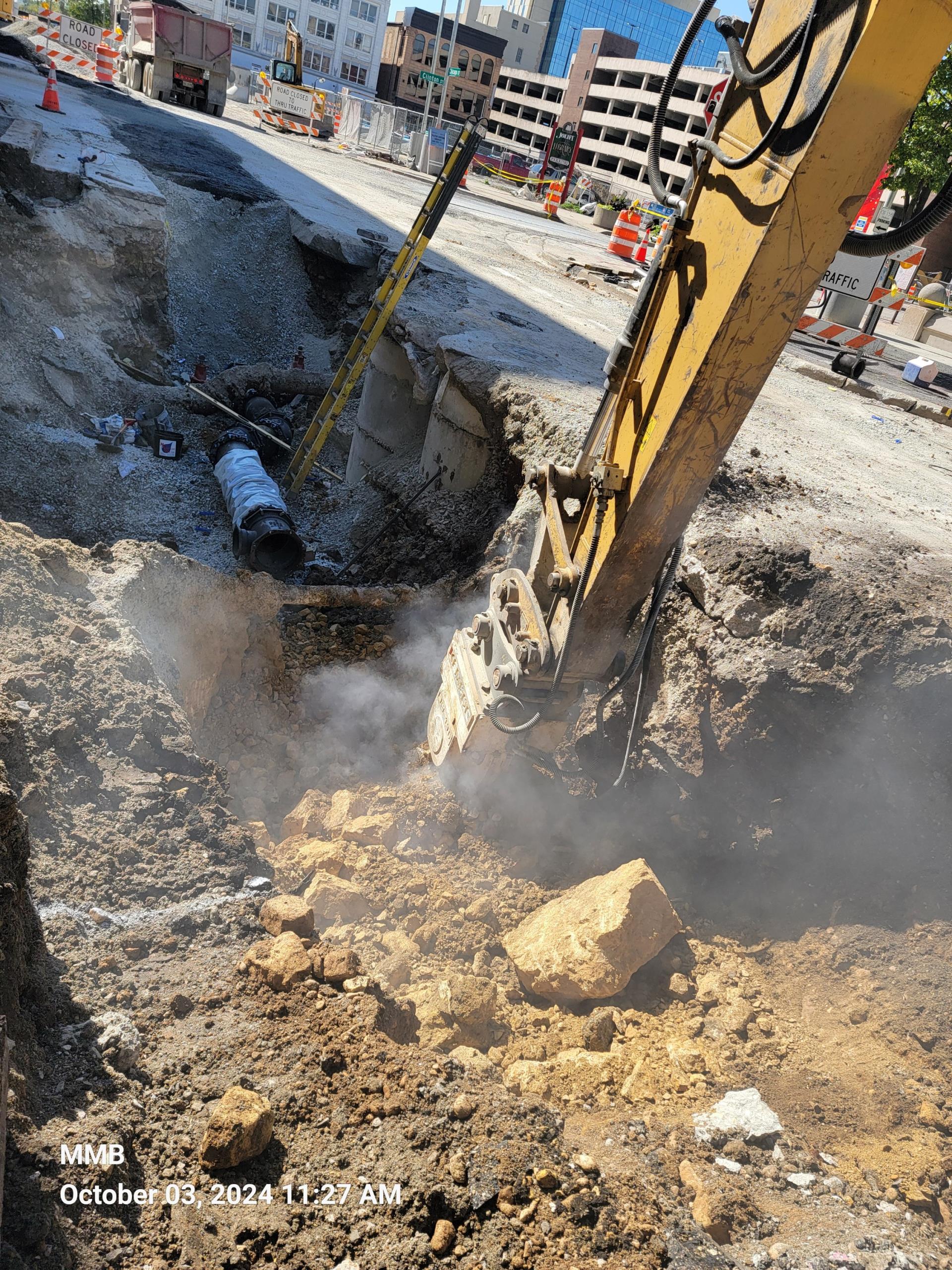 Rock excavation being performed to install water main under Clinton Street